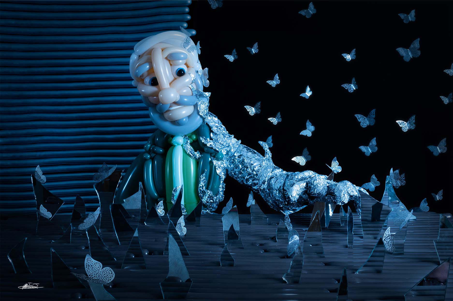 a shattered visage balloon sculpture of man with gray beard and green suit impaling his hand on broken mirror shard as tin foil envelops his arm with metal butterflies in background