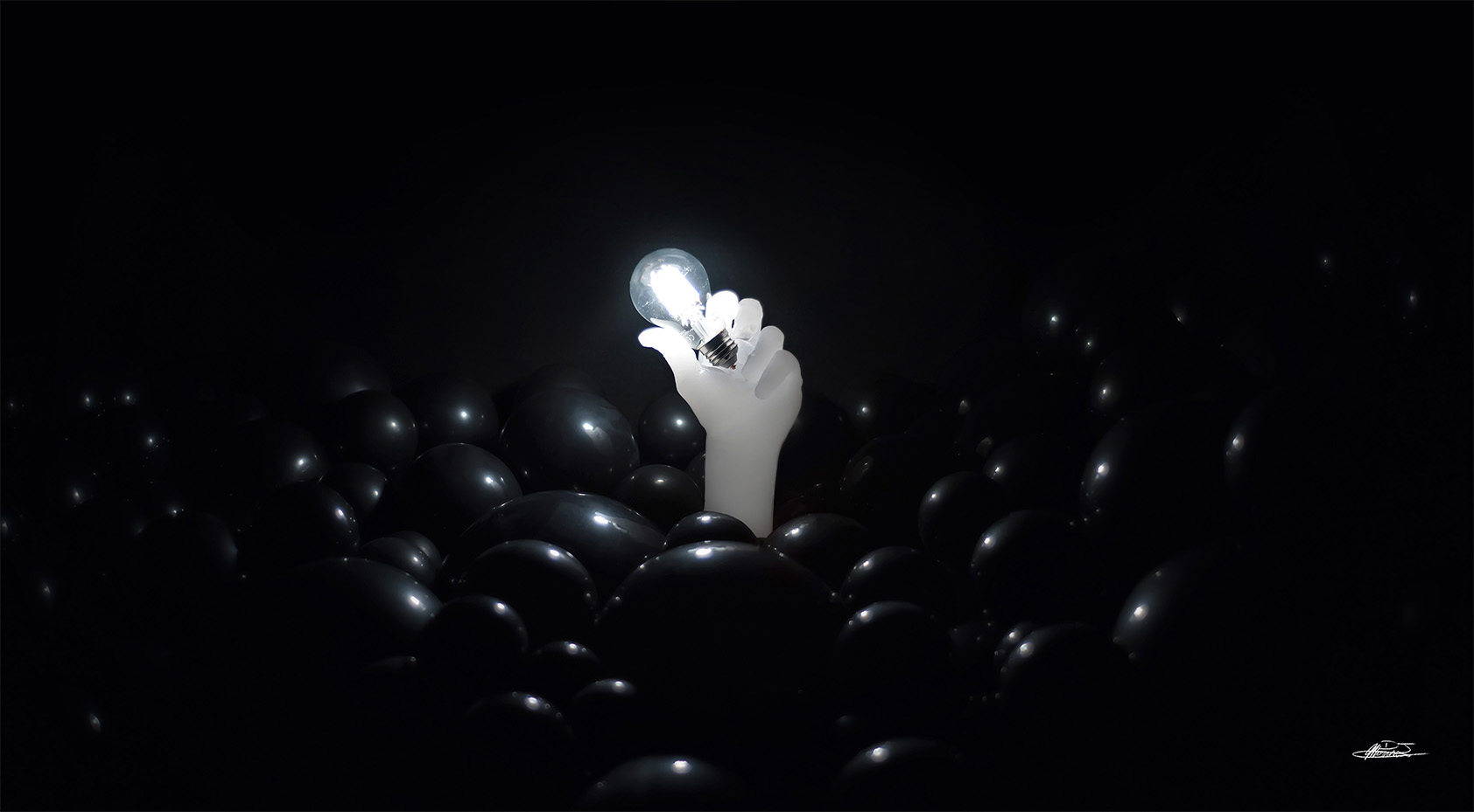 Reaching baloon sculpture wax hand reaching through sea of black balloon holding lit light bulb