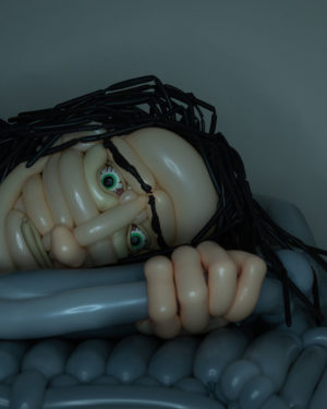 Sometimes Falling Asleep Feels Like Dying balloon sculpture of man in bed lying awake