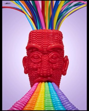 Stratification balloon sculpture of giant red head with colored balloons flowing into the top, vomitting out a rainbow